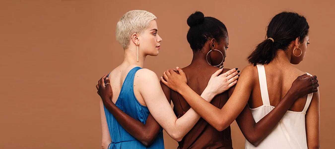 Three women with their arms around one another, in ACP’s original COVID-19 Stimulus Fund campaign image