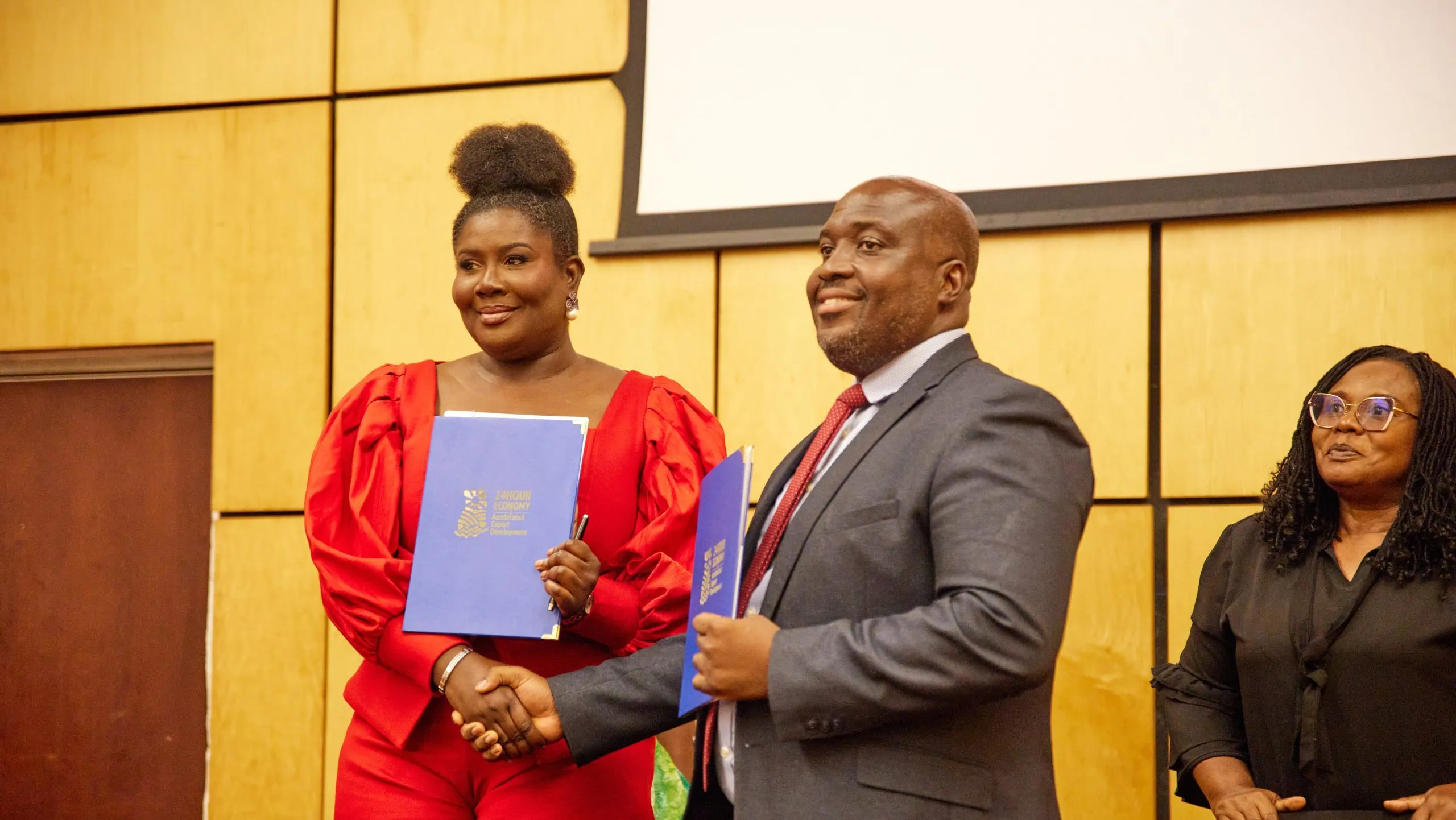 Representatives holding agreement folders at the ACP and 24H+ signing, with Roberta Annan on the left.